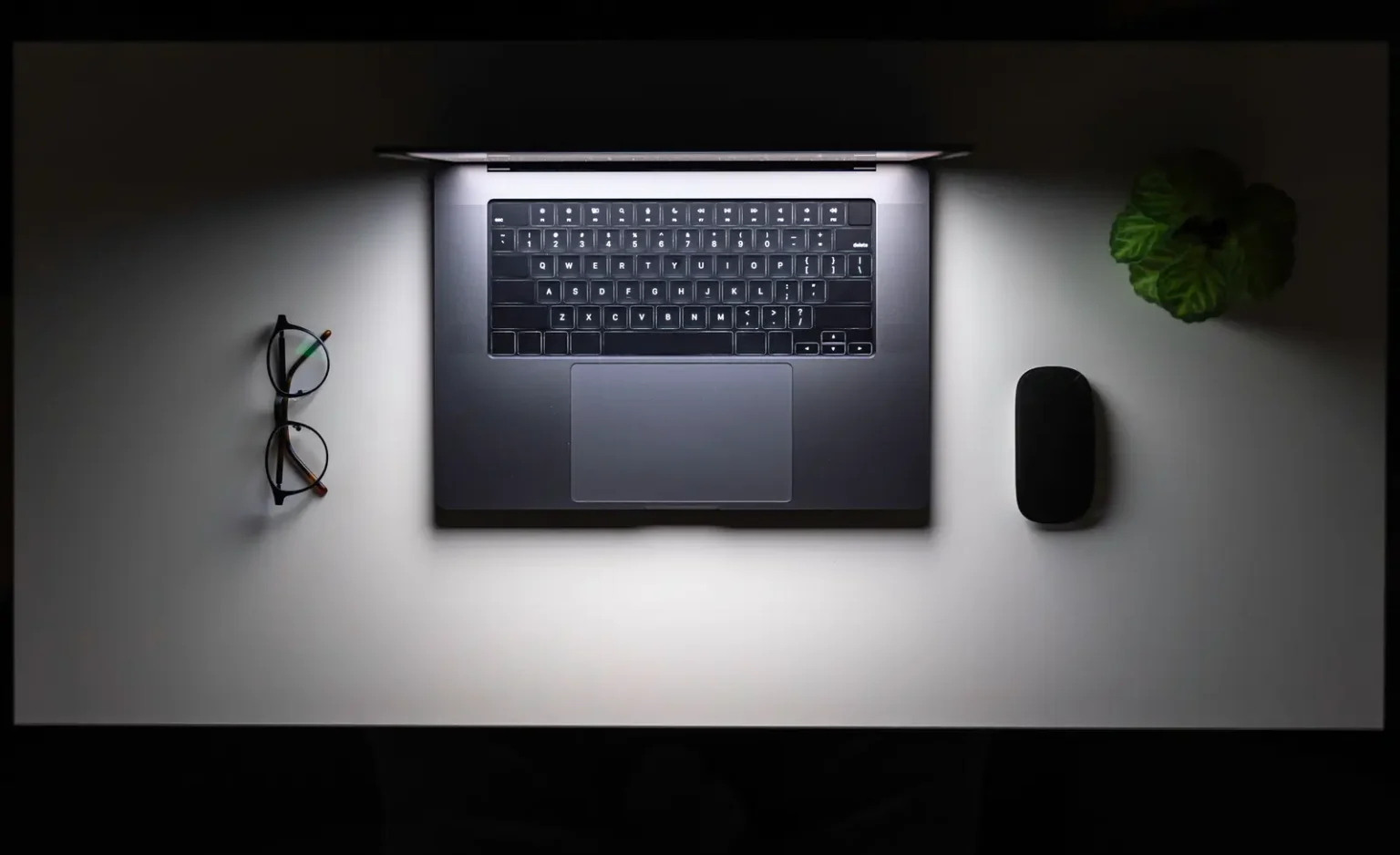 Laptop und Brille auf einem Schreibtisch